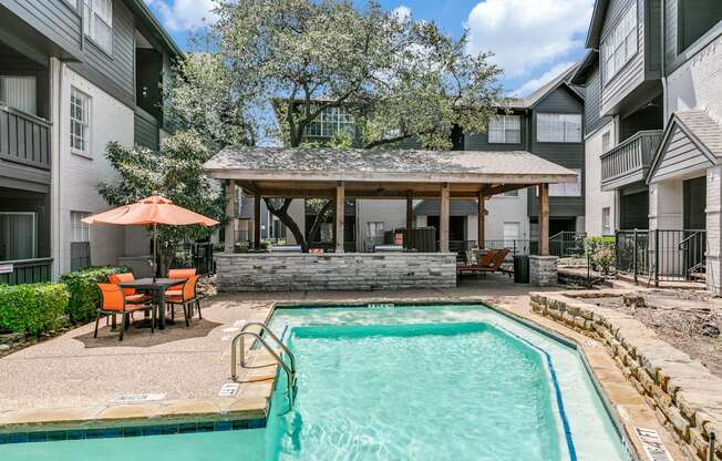 our apartments have a swimming pool and a patio with a table and chairs