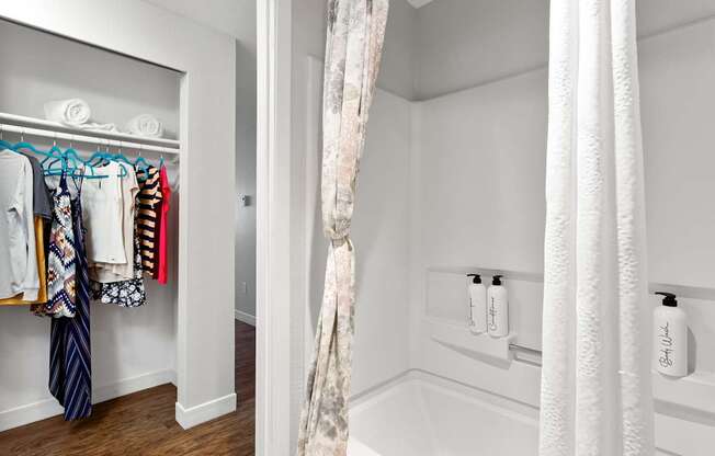 A white bathroom with a white tub and a white shower curtain.