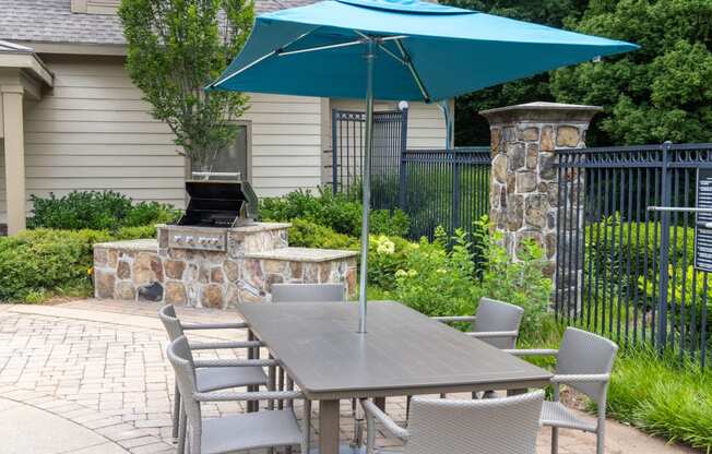 a table with chairs and an umbrella on a patio