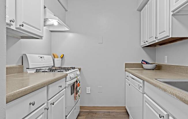 a kitchen with white cabinets and a stove and a sink