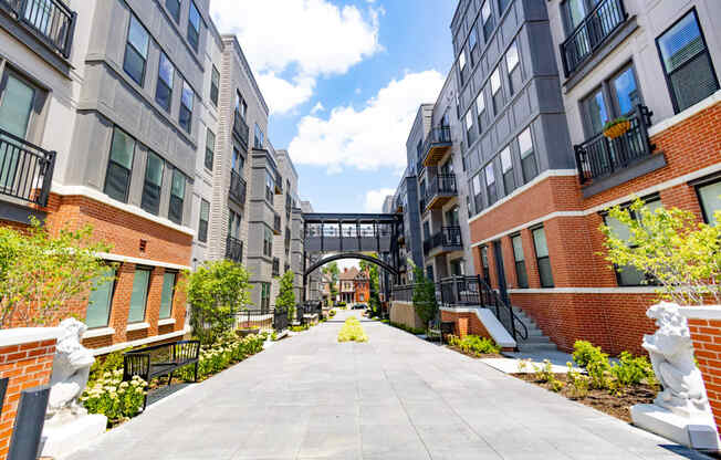 a courtyard between two apartment buildings with a bridge