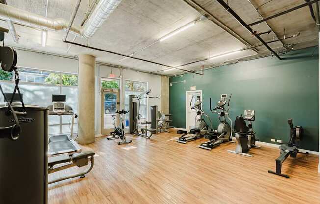 A gym with a variety of equipment including treadmills, stationary bikes, and weight machines.