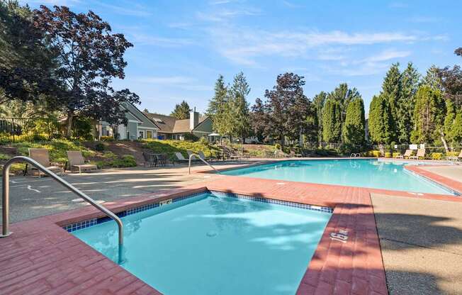 A small and large swimming pool surrounded by trees and a building in the background at Clackamas Trails Apartments, Oregon, 97222