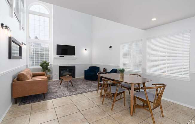 a living room with a table and chairs and a fireplace