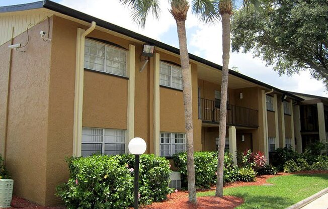 an apartment building with palm trees in front of it