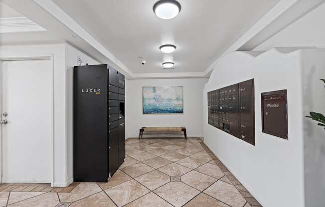 A room with a LUXE refrigerator and a painting of a beach scene on the wall.