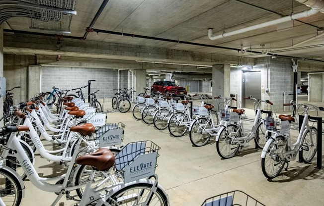 A bike rental station with many bikes and a red truck in the background.