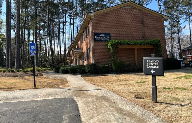 A brick building with a sign that says Leasing Center Parking.