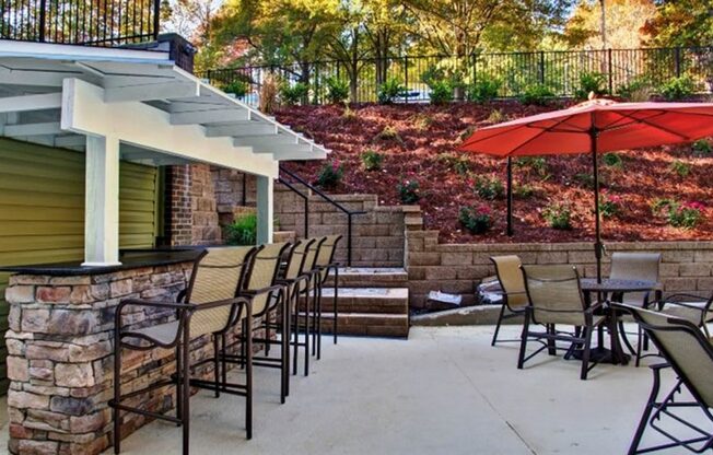 a patio with chairs and an umbrella