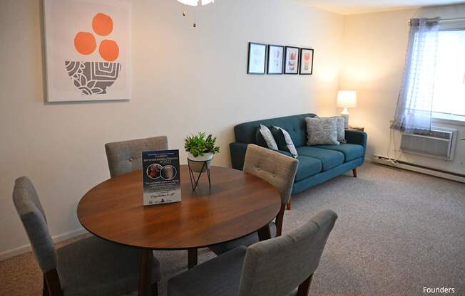 A living room with a grey couch, a brown table, and a painting on the wall.