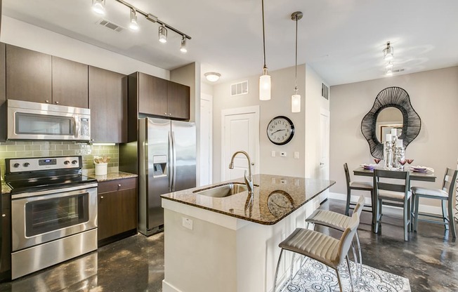A modern kitchen with a center island and stainless steel appliances.