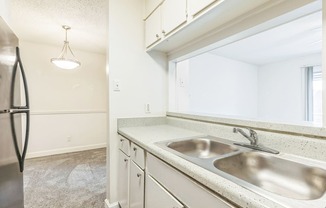 A kitchen with a sink and a refrigerator.