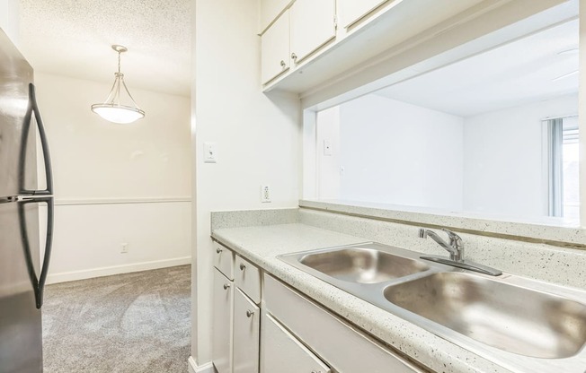 A kitchen with a sink and a refrigerator.