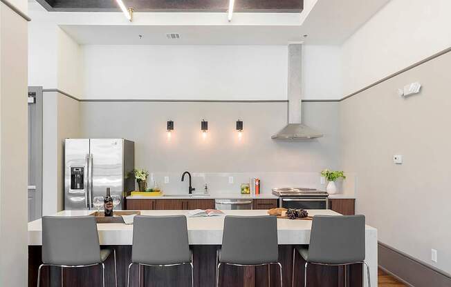 a kitchen with a long island with a bunch of chairs in front of it