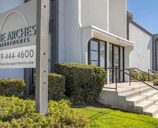 a building with stairs and a sign in front of it at The Arches Apartments, El Cajon, CA