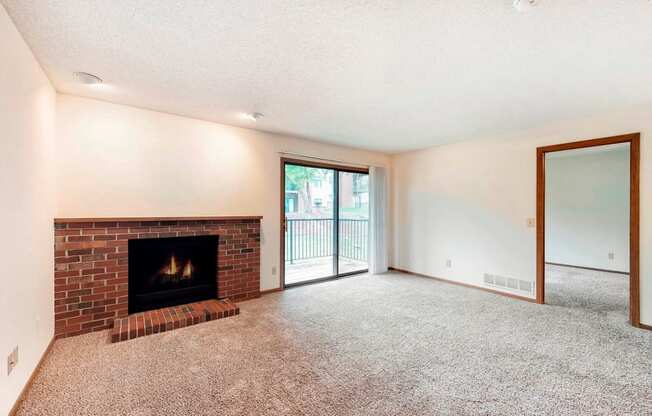 a living room with a fireplace and a door to a balcony