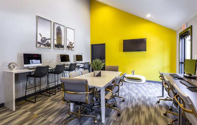 a conference room with a yellow wall and desks and chairs at The Hub at Baton Rouge, Baton Rouge