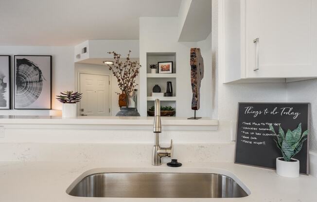 a white kitchen with a sink and a window