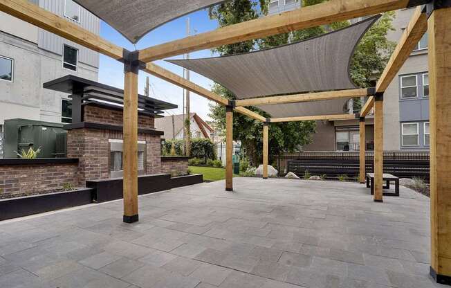 A patio with a grey roof and wooden pillars.