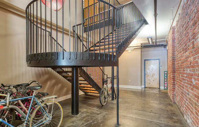 a spiral staircase in a loft with bikes parked under it