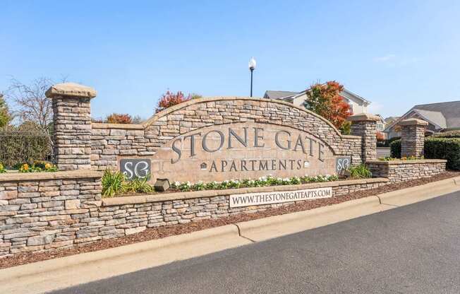 Stone Gate Apartments sign with a website address.