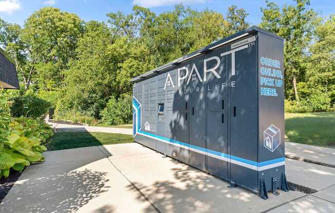 Apartment complex with a sign that says "Order Online Pick Up Here".