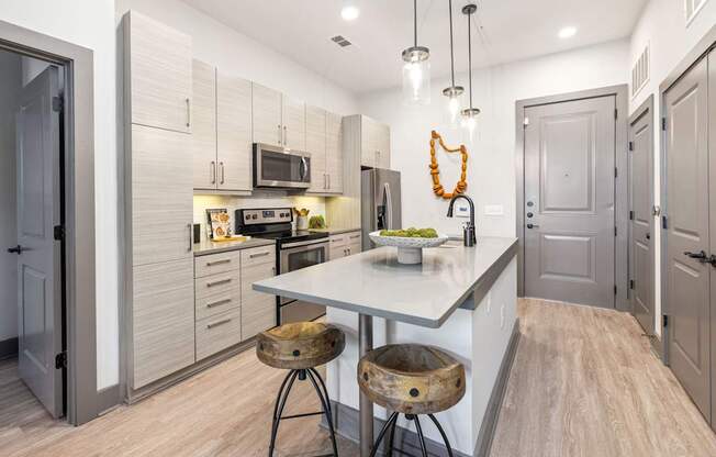 A kitchen with a white countertop and wooden flooring.