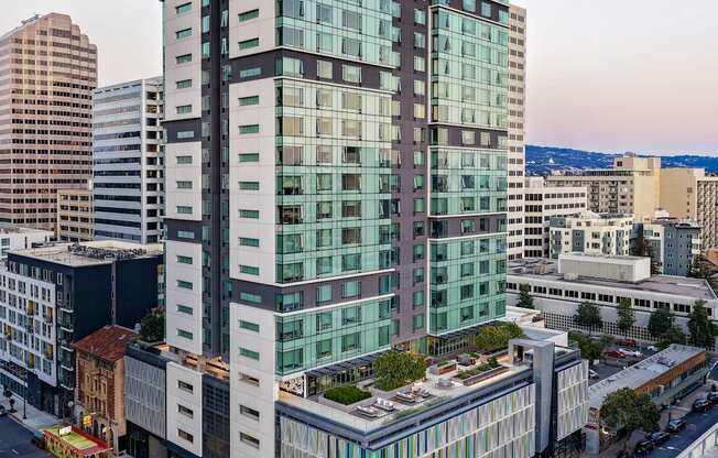 A modern glass building is situated on a busy street.