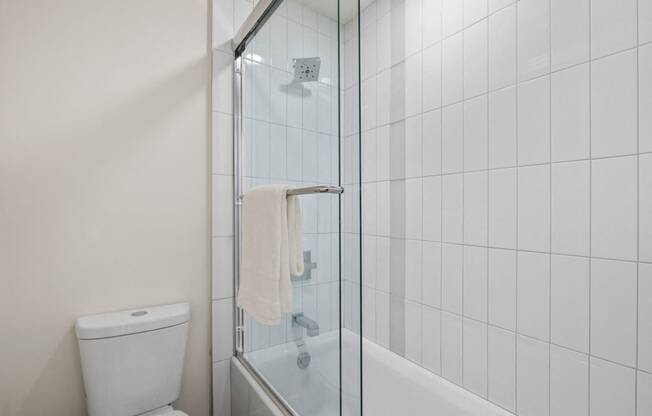 a white bathroom with a shower and a toilet