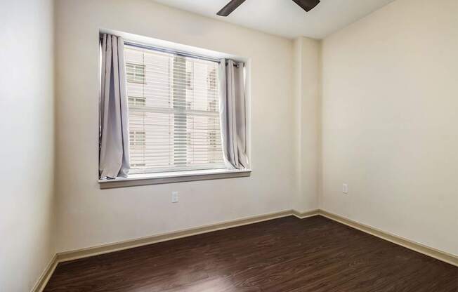 A room with a window and a ceiling fan.