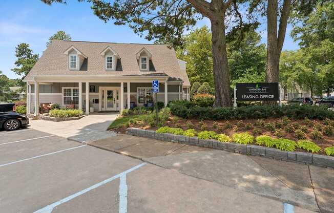 A building with a sign that says "Leasing Office" in front of it.