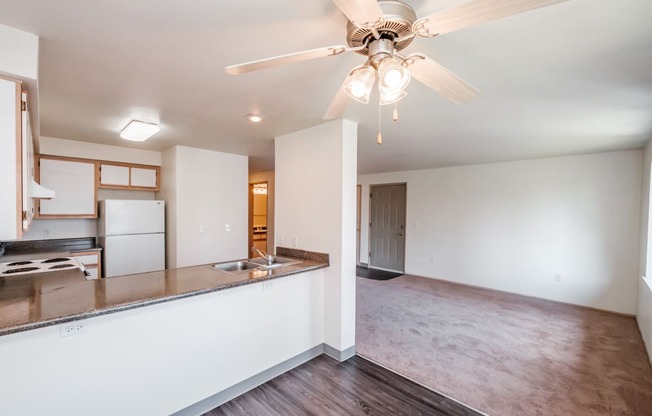 a kitchen and living room with a ceiling fan