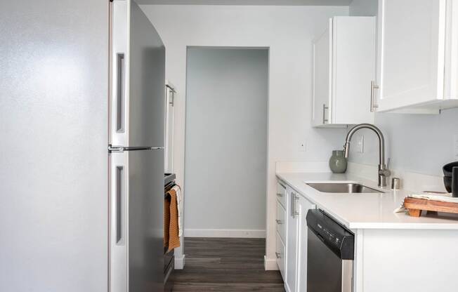 a kitchen with white cabinets and a stainless steel refrigerator