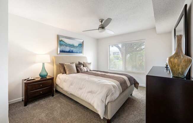 a bedroom with a bed and a ceiling fan