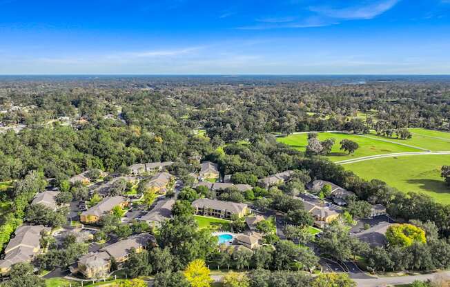 an aerial view of a neighborhood with houses and trees and a golf course