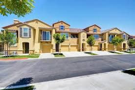 A row of houses with a driveway in front.