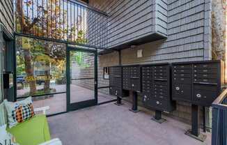 A row of mailboxes are lined up on a wall outside a building.