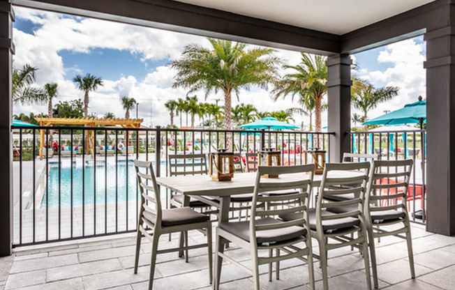 outdoor table with dining chairs next to pool in daytime