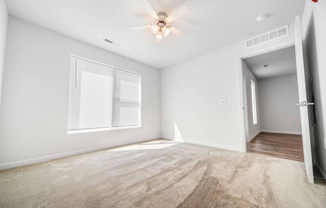 a bedroom with a ceiling fan and a window  at Union at Wiley, Cedar Rapids, IA