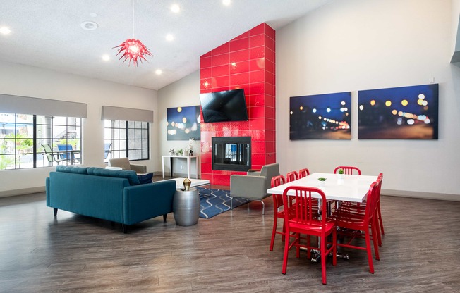 a living room with a red accent wall and a dining room table and chairs
