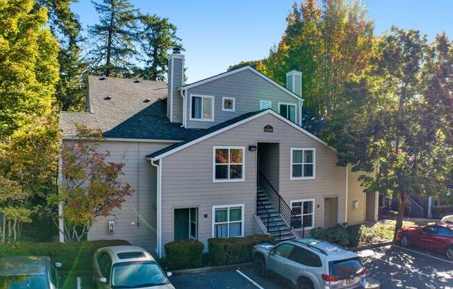 the front of a house with cars parked in a parking lot