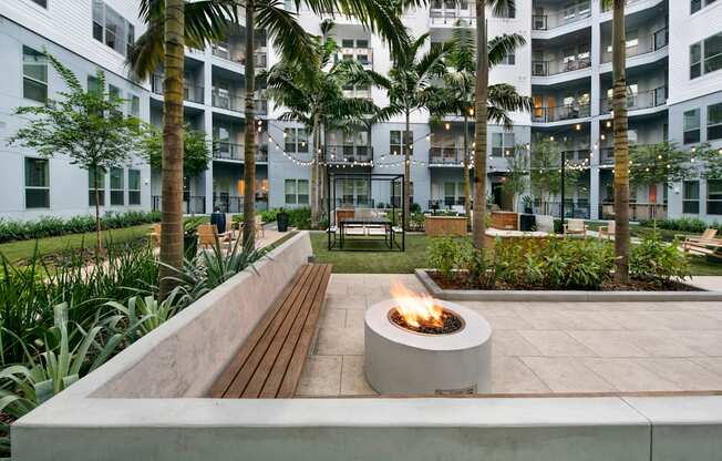 a fire pit in the courtyard of an apartment building