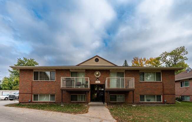 an apartment building with two balconies and a sidewalk. Fargo, ND Country Club Apartments.