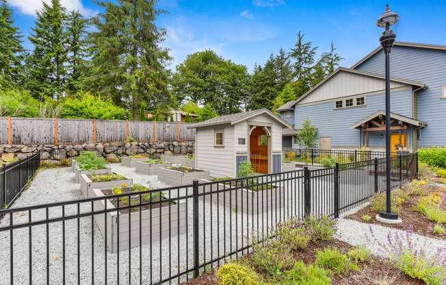 Gated community garden with raised planter boxes or growing items on-site. 