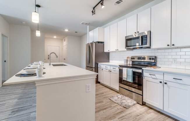 a kitchen with white cabinets and a counter top and a stove