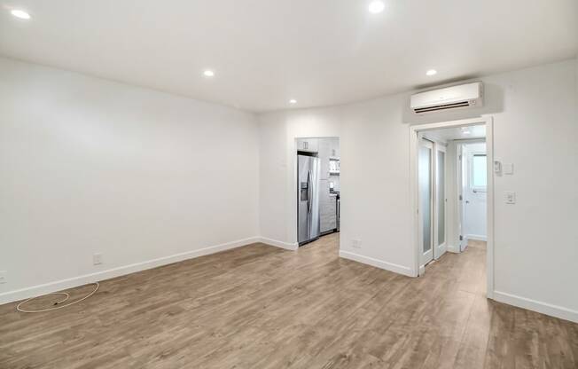 a living room with white walls and a wooden floor