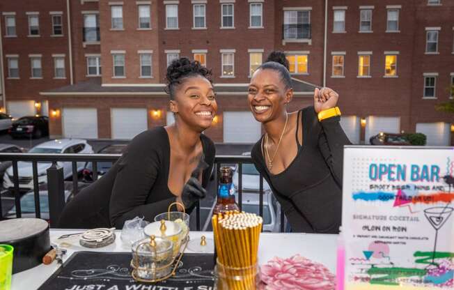 two women sitting at a table at an open bar event