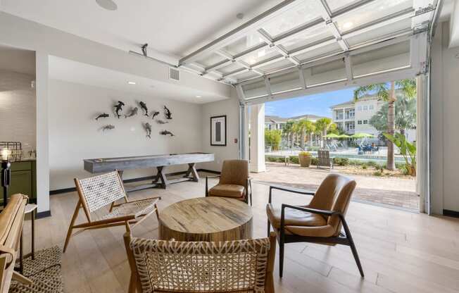 a living room with a ping pong table and chairs