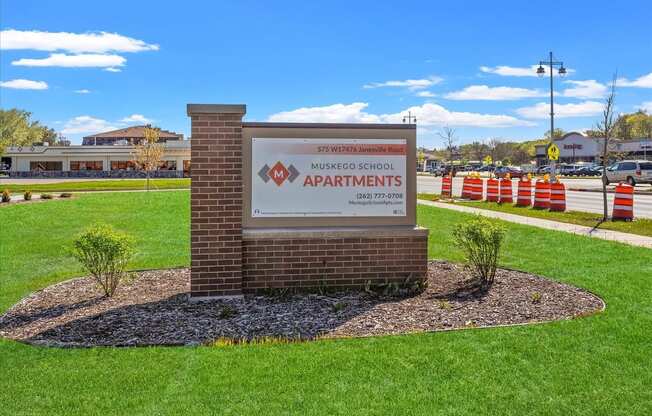 The monument sign beside the road at Muskego School Apartments