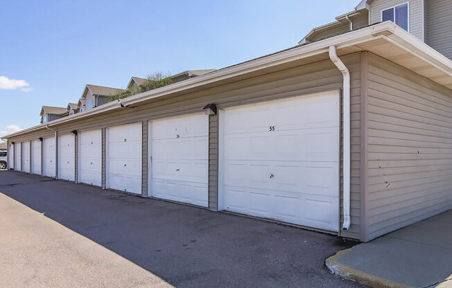 a row of white garage doors on a house